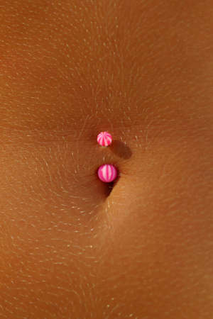 Pink and white belly button piercing in young women