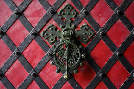 Door knocker covered with green patina on the red gates in the Krivoklat castleの写真素材