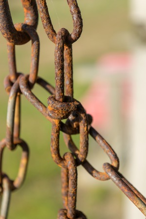 Old rusty chain and chain links against a natural green bokeh background, close-up, Block Island, RIの写真素材