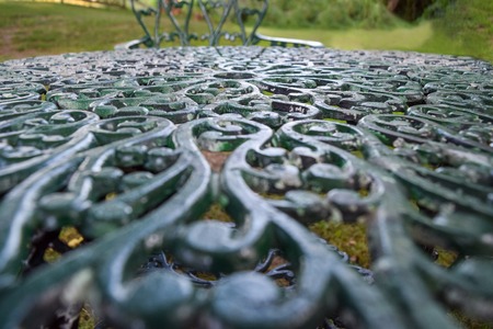 Intricately ornamented cast-iron tabletop in a gardenの写真素材