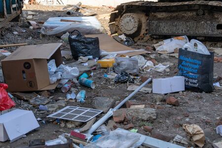 New York City, NY/USA - 03/19/2019: Garbage and discarded household items lying on a dirty street in...
