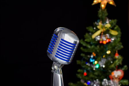 Closeup of an old-fashioned microphone with blurry Christmas tree in the backgroundの写真素材