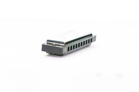 Closeup of a simple metal harmonica in C, isolated on a white background
