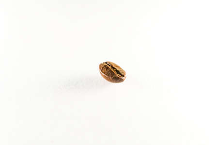 Close-up of a single roasted coffee bean, isolated on a white backgroundの写真素材