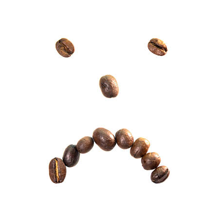 Close-up of roasted coffee beans in the shape of a sad face, isolated on a white backgroundの写真素材
