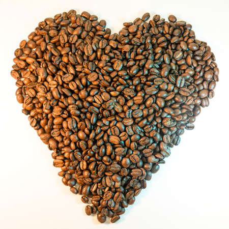 Roasted coffee beans in the shape of a heart isolated on a white backgroundの写真素材