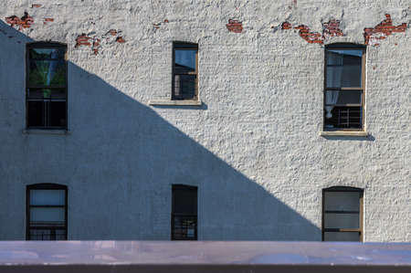 A textured white brick wall and windows on a sunny afternoon in the Bronx, New York City, NY, USAの写真素材