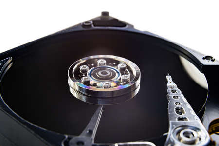 Close-up of an old fashioned, open, mechanical harddisc drive, isolated on a white backgroundの写真素材