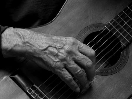 Detail of wrinkled hands of an old guitaristの写真素材