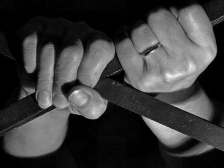 Woman hands behind barsの写真素材