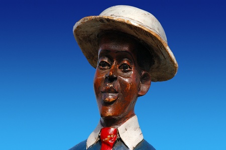 Detail of head African sculpture in colored wood on blue skyの写真素材