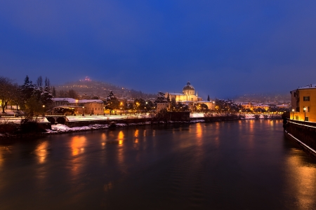 The Adige river and hills with snow in winter - Verona by night - Veneto Italyの写真素材