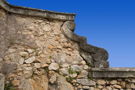 An old country stone wall with a ornament on blue skyの写真素材