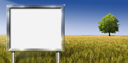 Realistic advertising gray chrome billboard in country landscape with big treeの写真素材