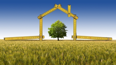 Wooden yellow meter tool forming a ecologic house in the countryside with treeの写真素材