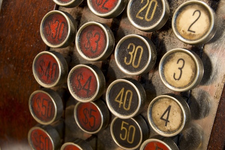 A detail of a vintage dirty cash register with currency in dollarsの写真素材