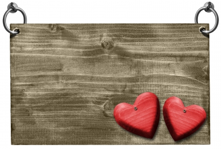 Empty wooden signboard hanging on to two steel ring with two wooden red hearts の写真素材