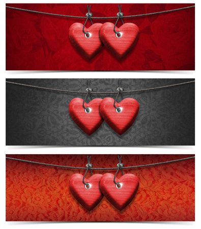 Two handmade red wooden hearts hanging on a steel cable on fabric 
の写真素材