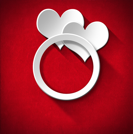 Two stylized white hearts and wedding ring on red velvet background with shadowsの写真素材