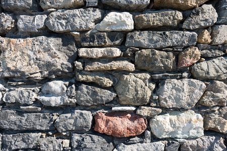 An old gray and brown stone wall makes an excellent backgroundの写真素材