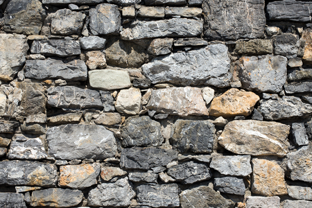 An old gray and brown stone wall makes an excellent backgroundの写真素材