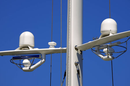 Detail of luxury white yacht with navigation equipment, radar and antennas on blue skyの写真素材