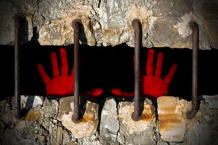 Two bloody red hands on a prison, concept of violence and injusticeの写真素材
