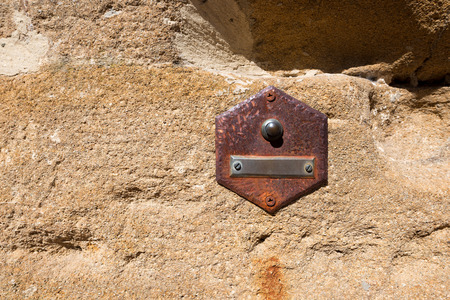 Rusty doorbell button on brown stone wall in San Gimignano town  UNESCO heritage , Siena, Tuscany, Italyの写真素材