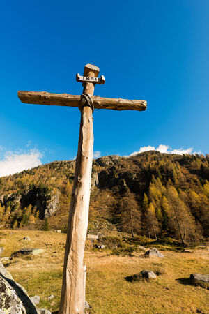 Old wooden cross (trunks of trees) tied with ropes with blue sky and clouds in the National Park of Adamello Brenta. Trentino Alto Adige, Italyの写真素材