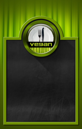 Empty blackboard with green frame on green background with vegetables and vegan symbol with empty white plate and silver cutlery, fork and knifeの写真素材