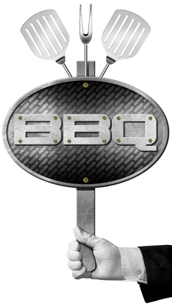 Hand of chef holding a metal barbecue sign with metallic grill, kitchen utensils, fork and two spatulas. Isolated on white backgroundの写真素材