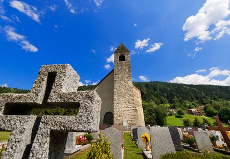 Ancient mountain church of San Vigilio 1515 with cemetery in Pinzolo, Trento Italyの写真素材