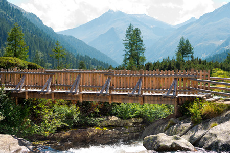 Small wooden bridge of a trekking path on the Chiese river in the National Park of Adamello Brenta, Val di Fumo. Trentino Alto Adige, Italyの写真素材
