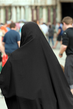 Traditional Muslim woman with black veil view from behindの写真素材