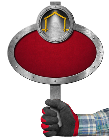 Hand with work glove holding a oval metal sign with a meter ruler in the shape of house. Empty sign for the construction industry, isolated on whiteの写真素材