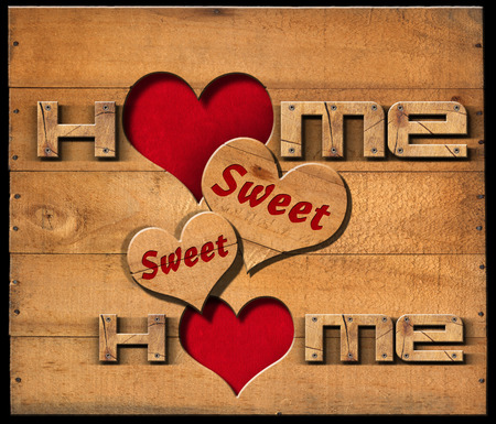 Wooden text Home sweet home with two hearts on a wooden wall isolated on a black backgroundの写真素材