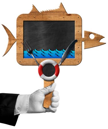 Hand of chef holding a blackboard in the shape of fish with cutlery, blue waves and lifebuoy. Isolated on white backgroundの写真素材