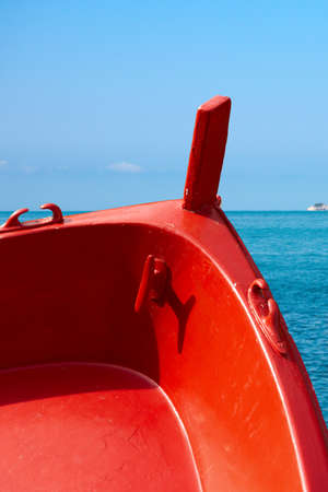 Detail of a wooden red prow of a rowing boat with sea in background. Liguria, Italyの写真素材
