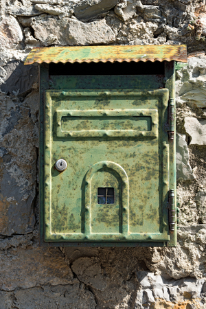 Detail of an Italian rusty metallic mailbox, hanging on a wall. Portovenere, Liguria, Italyの写真素材