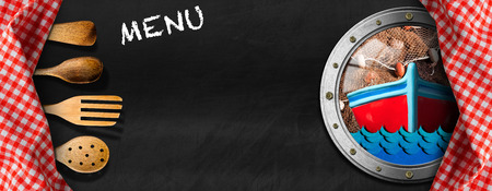 Empty blackboard with a porthole, fishing boat, waves, fishing net and checkered tablecloths with wooden kitchen utensils. Template for a fish menuの写真素材