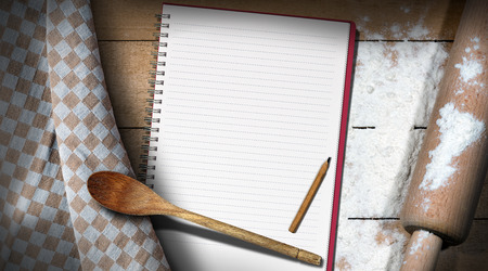 Empty notebook for recipes or ingredients list on a table with flour, wooden rolling pin, spoon and brown and white checkered tableclothの写真素材