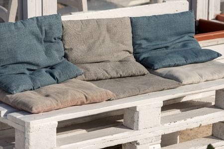 Sofa made of white wooden pallet and cushions of cloth. Outdoor settingの写真素材