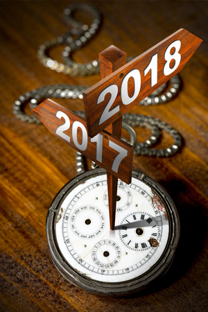 Happy New Year 2018 - Old pocket watch with two wooden signs with arrows and the years 2017 and 2018
の写真素材