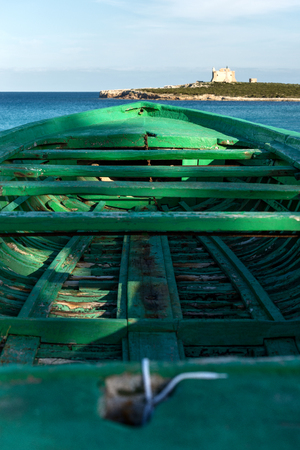 The Capo Passero Island (Cape Passero) with a boat of migrants. Portopalo, Syracuse, Italy, Europeの写真素材