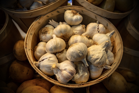Close-up of a basket of white garlic bulbs on sale at the marketの写真素材