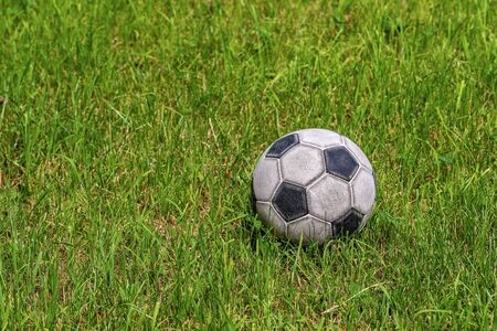 Old leather soccer ball on green grass with copy space, football sport conceptの写真素材