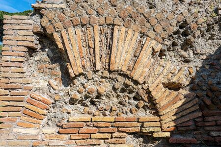 Old ruins of a Roman building with a brick wall and arch. Ostia Antica, colony founded in the 7th century BC. Rome, UNESCO world heritage site. Latium, Italy, Europeの写真素材