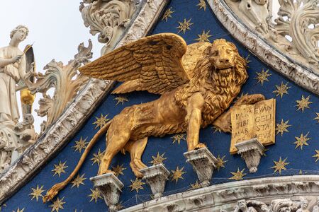 Venice, close up of the golden winged lion of St Mark, symbol of the evangelist and the Venetian Republic. Basilica and Cathedral of San Marco, UNESCO world heritage site, Veneto, Italy, Europeの写真素材