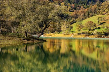 Lago di Tenno, close-up of a small and beautiful lake in Italian alps with an island in autumn. Trento province, Trentino-Alto Adige, Italy, Europeの写真素材