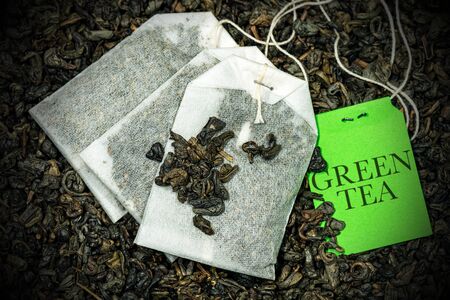 Close-up of a three green tea bags, Gunpowder tea, with label on many dried leaves for preparing a hot drinkの写真素材